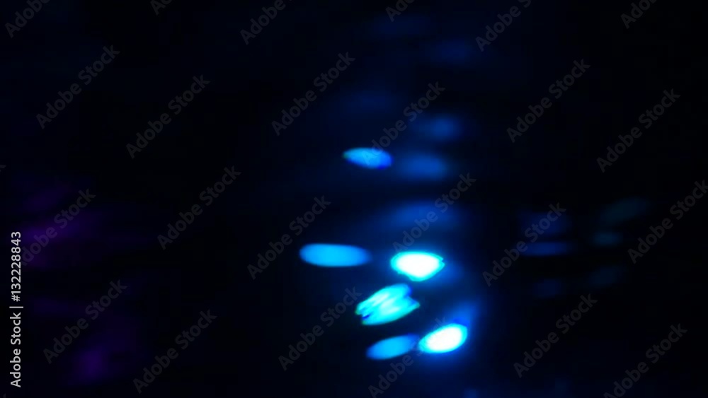 Abstract defocused lights on the surface of the water in the pool.