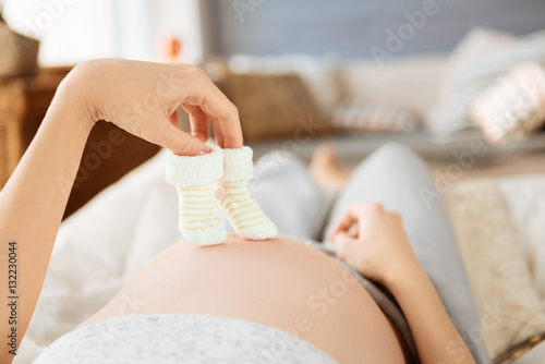 Close up of a pregnant woman holding baby socks