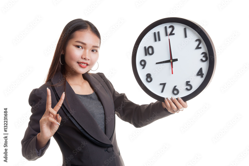 Young Asian business woman show victory sign with a clock. Young Asian business woman show victory sign with a clock.