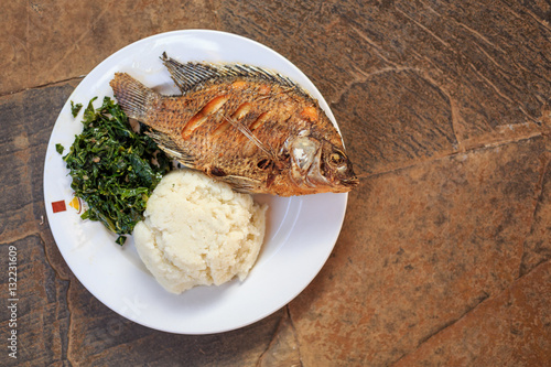 Fotografie Traditional african food - ugali, fish and greens