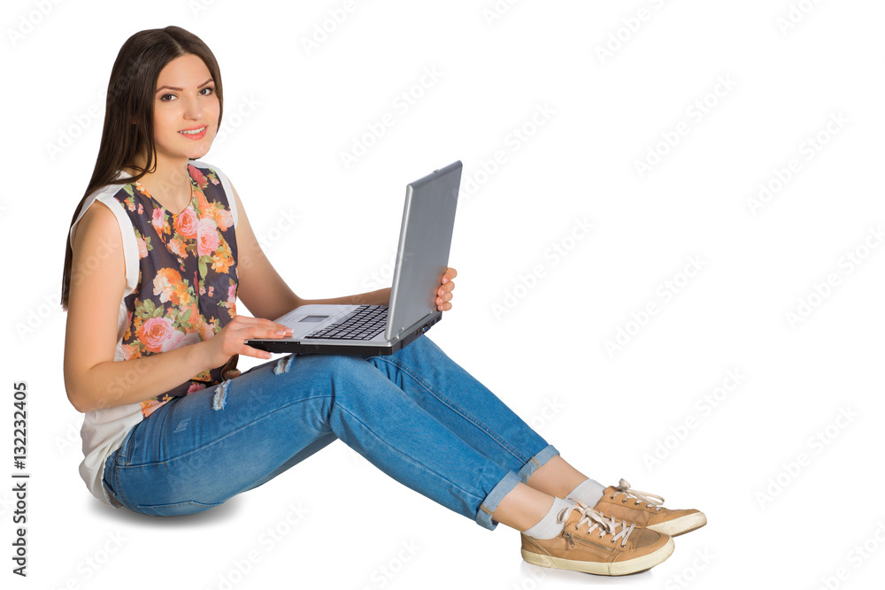 Young girl in jeans with laptop sitting on floor Stock Photo | Adobe Stock