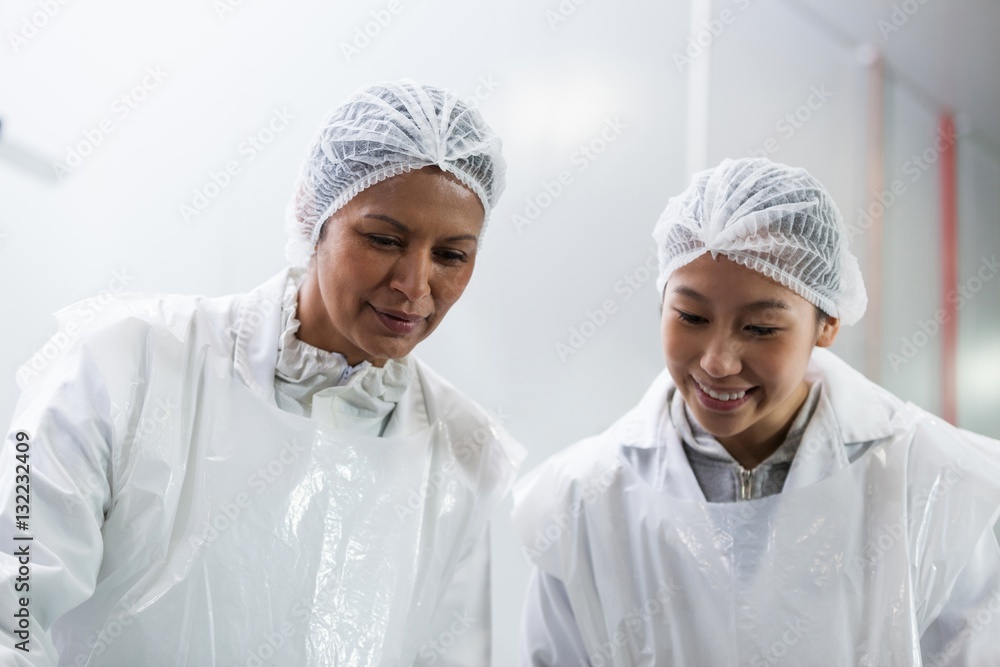 Female butcher working at meat factory