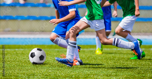 Fototapeta Naklejka Na Ścianę i Meble -  Young Boys Kicking Football on the Sports Field