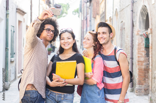 Group of multiracial students taking a selfie in the city. photo