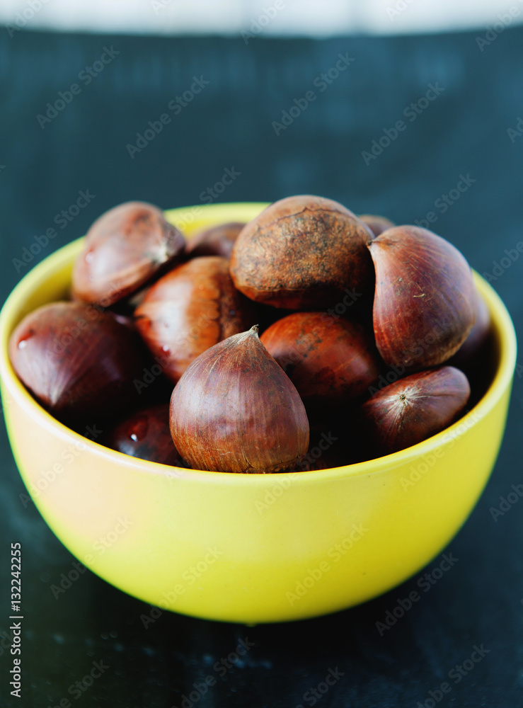 Obraz premium Fresh chestnuts in yellow bowl