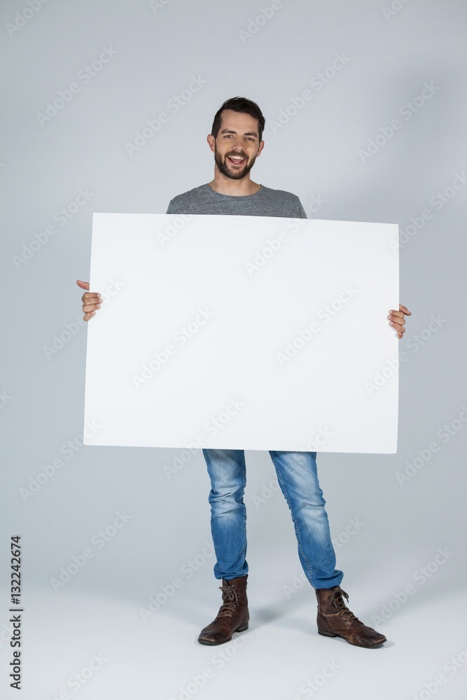 Handsome man holding a blank placard Handsome man holding a blank placard