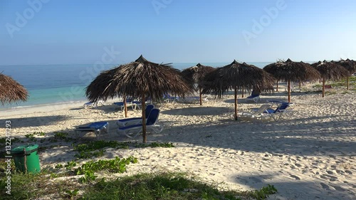 Empty sunbeds with parasols at the beach of the Cayo Levisa island. Cuba. photo