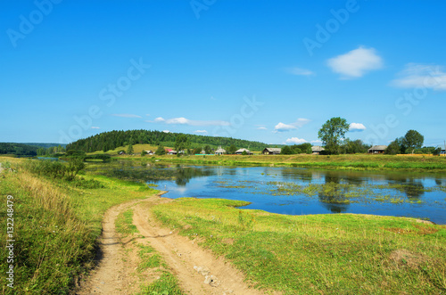 Rural landscape with village by the river
