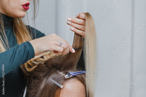 hands of woman combing hair and doing bouffant her client in beauty salon