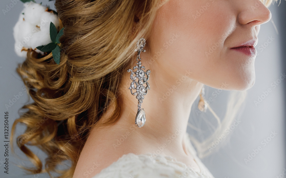 Macro close-up of jewelry earrings and wedding hairstyle
