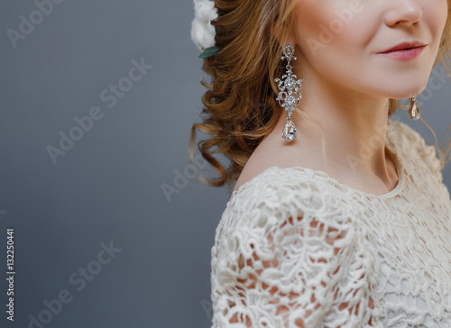 Detail of young woman wearing beautiful luxury earring and hairstyle with copy space