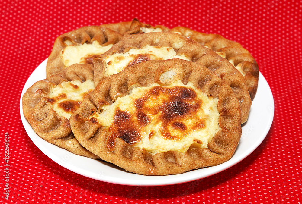 patty with potatoes in a white plate on a red background patty with potatoes in a white plate on a red background