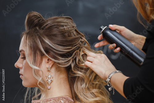 Valokuva Hairdresser using hairspray on client's hair at salon