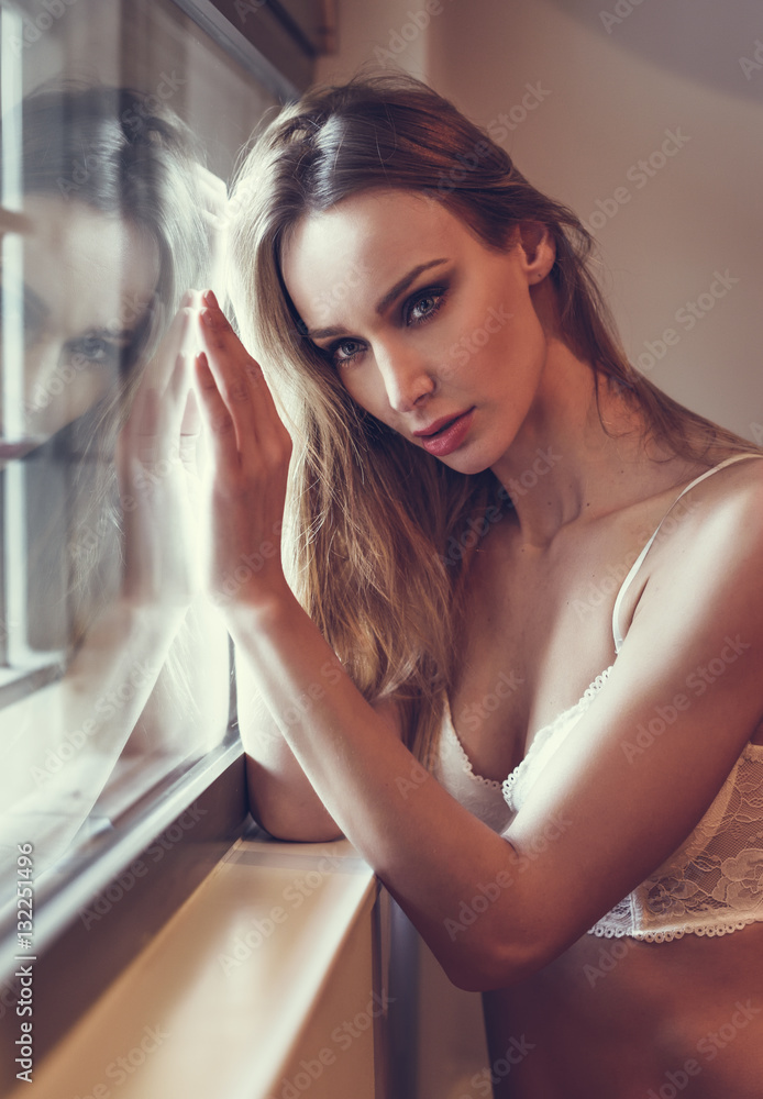 Photo shoot a young girl in white lingerie at the window. Stock Photo