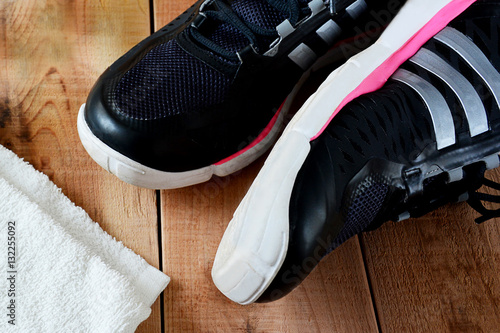 Black sport shoes and towel on wooden.