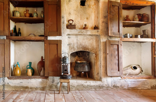 Interior of old house in Georgia country, with kitchen utensils, kettle, primus, fireplace and wooden floor