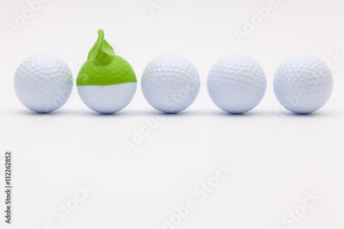 White golf balls with funny cap on the white background.