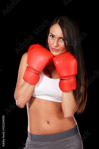 Young sexy girl over black background with boxing gloves