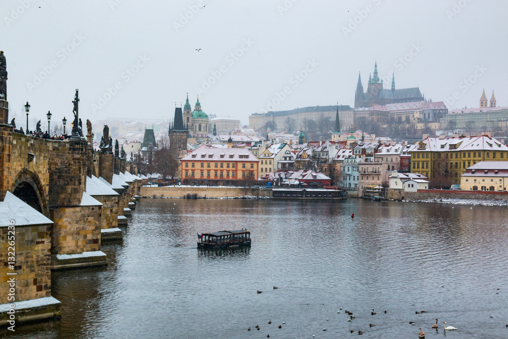 Prague castle and Charles bridge in snowy winter day