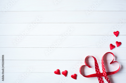 Wooden background with red hearts from ribbon