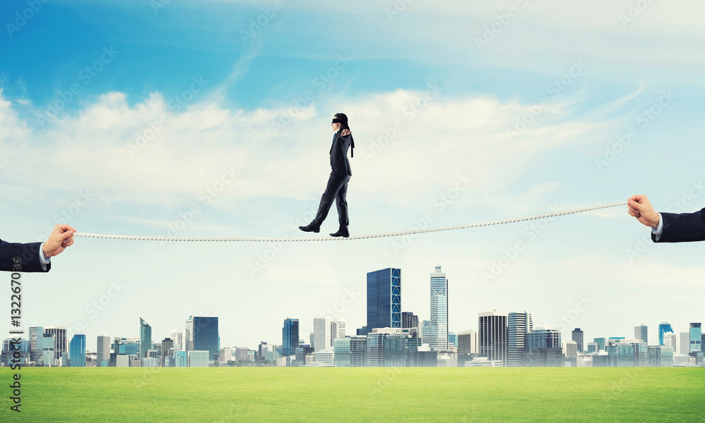 Business concept of risk support and assistance with man balancing on rope