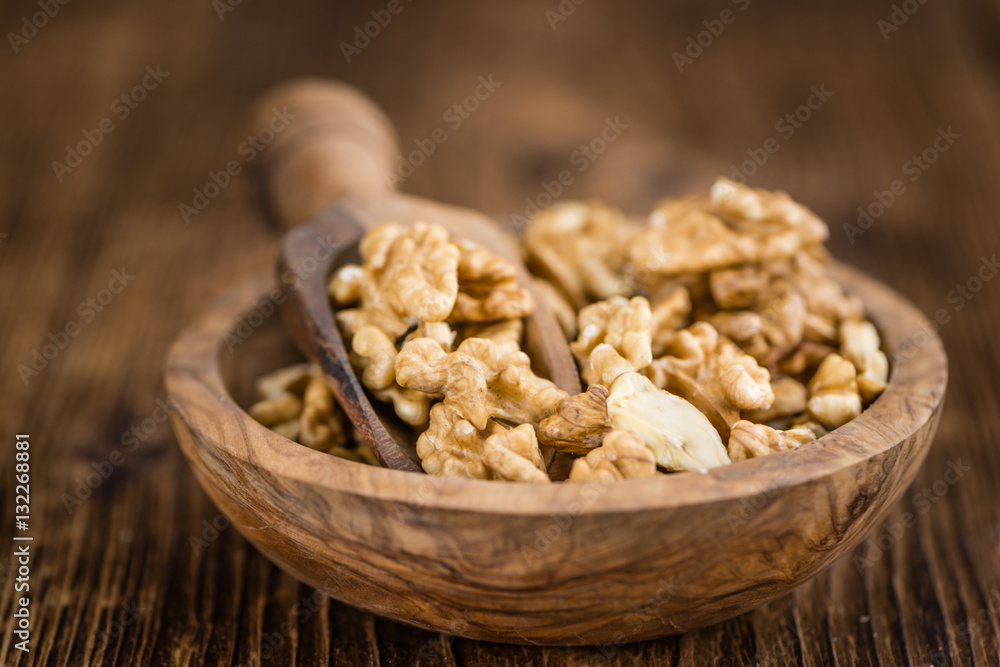 Portion of Cracked Walnuts on wooden background (selective focus Portion of Cracked Walnuts on wooden background (selective focus