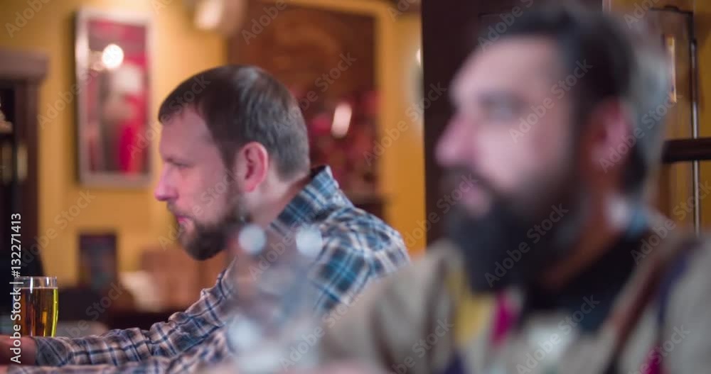Men pub guests drinks beer at bar counter 4k refocus video. Male visitors taste lager, focus change between man clients Men pub guests drinks beer at bar counter 4k refocus video. Male visitors taste lager, focus change between man clients