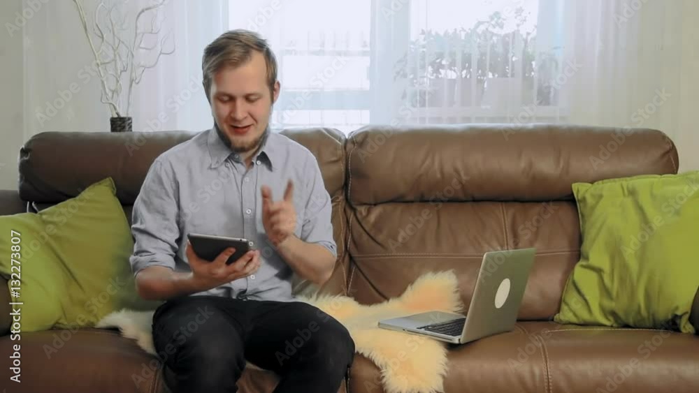Young businessman with a digital tablet telling good new to the camera Young businessman with a digital tablet telling good new to the camera