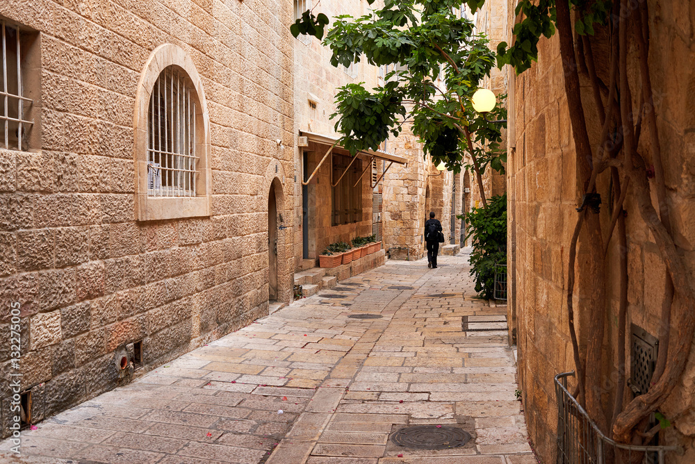 Man siluette walking on empty istreet n old town of Jerusalem. J