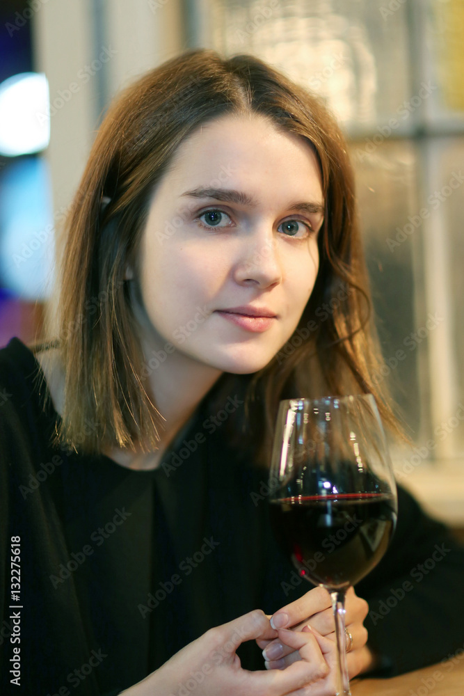 Closeup portrait of a pretty girl with a glass/Portrait of elegant charming young glamour woman in restaurant with glass of red wine Closeup portrait of a pretty girl with a glass/Portrait of elegant charming young glamour woman in restaurant with glass of red wine