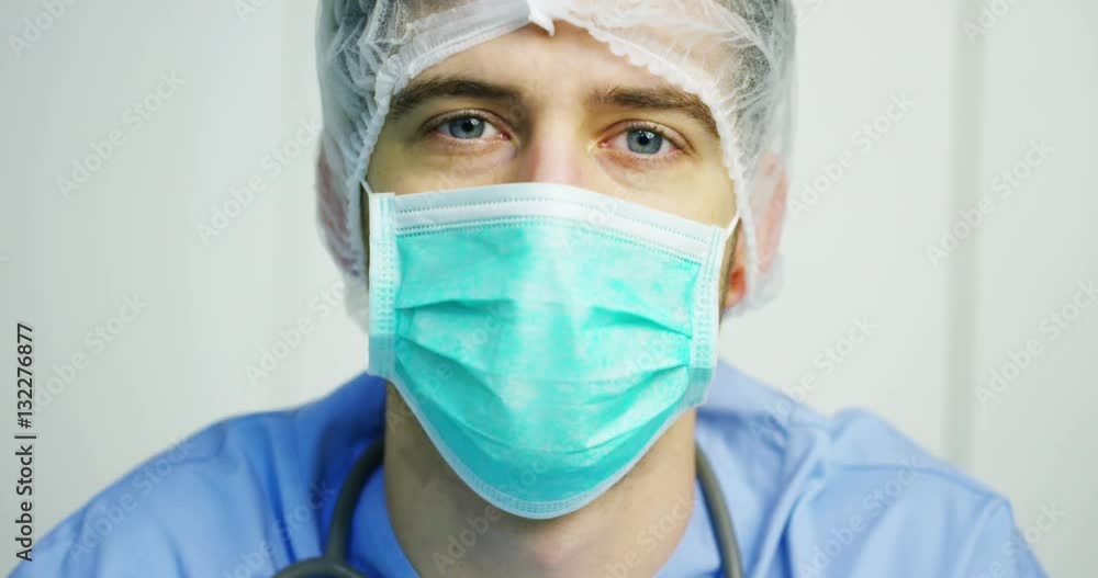 close up portrait of a surgeon or doctor with mask and headset ready for operation in hospital or clinic. The surgeon smiles safe and proud of himself. Concept of medicine, hospitals and doctors, care close up portrait of a surgeon or doctor with mask and headset ready for operation in hospital or clinic. The surgeon smiles safe and proud of himself. Concept of medicine, hospitals and doctors, care