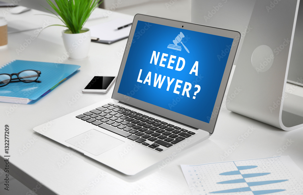 Modern laptop on table. Text NEED A LAWYER? on screen Modern laptop on table. Text NEED A LAWYER? on screen