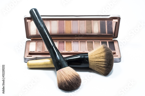 Brush and colorful eye shadow for make up on white background.