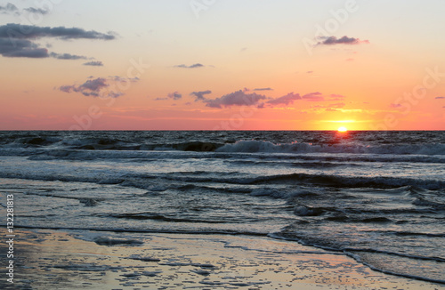 The sun rising over the ocean. Background with the first rays of the sun rising over the Atlantic Ocean.