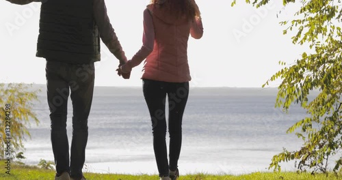 Young Couple Walk To River Bank, Man And Woman Holding Hands Outdoors In Autumn Park Natural Light Slow Motion 60