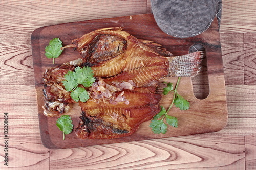 Ready served deep fried fish ,Nile tiapia, on butcher served. photo