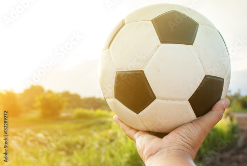 Hand holding soccer ball.