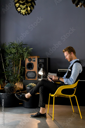 Young man with tablet sitti...
