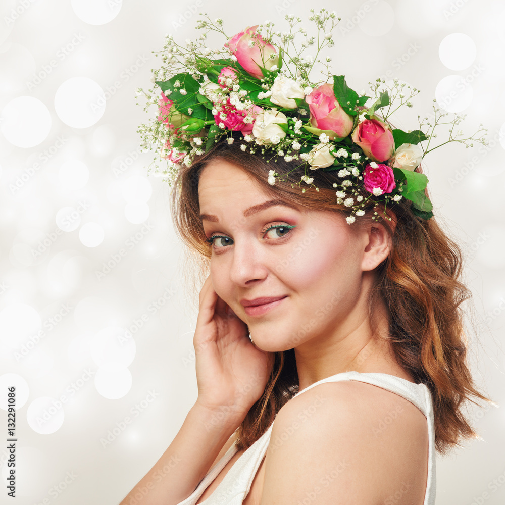 Portrait of a cute smiling young girl in a wreath of roses