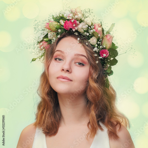 Portrait of a young girl in a wreath of roses