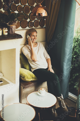 Woman sitting in cafe and u...