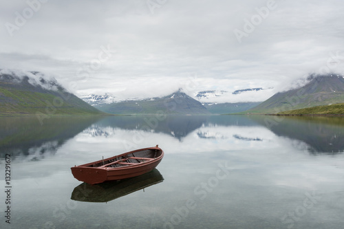 Iceland fjord with red wooden boat