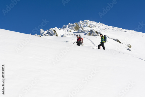 Hikers on a snowy ridge.