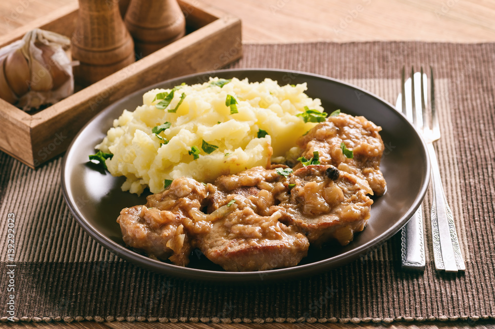 Pork tenderloin cooked in onion sauce served with mashed potatoes. Pork tenderloin cooked in onion sauce served with mashed potatoes.