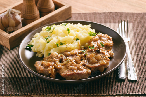 Pork tenderloin cooked in onion sauce served with mashed potatoes.