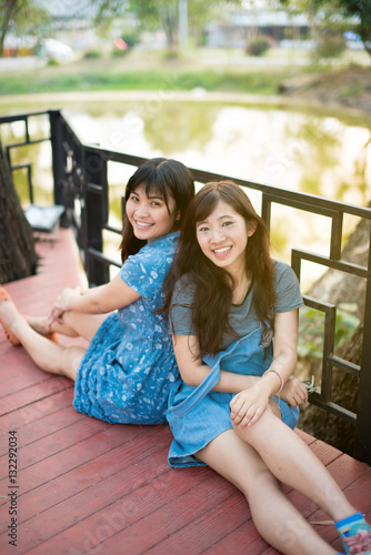 Two friend women relaxing in park enjoying her freedom wear short dress