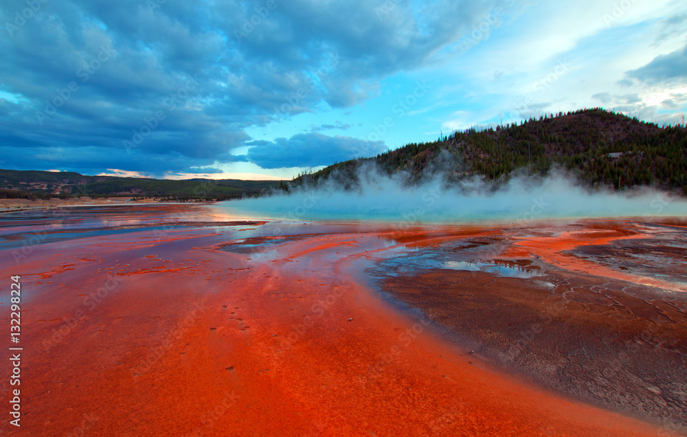 The Grand Prismatic Spring at sunset in the Midway Geyser Basin along the Firehole River in Yellowstone National Park in WY The Grand Prismatic Spring at sunset in the Midway Geyser Basin along the Firehole River in Yellowstone National Park in WY