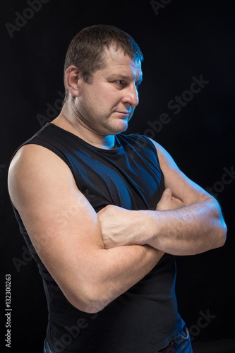 Brutal man actor gesticulates and grimaces on a black background. photo