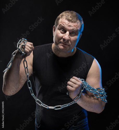 Brutal man actor gesticulates and grimaces on a black background. photo