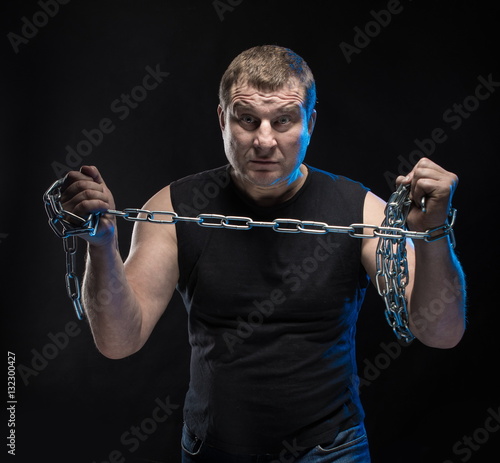 Brutal man actor gesticulates and grimaces on a black background. photo